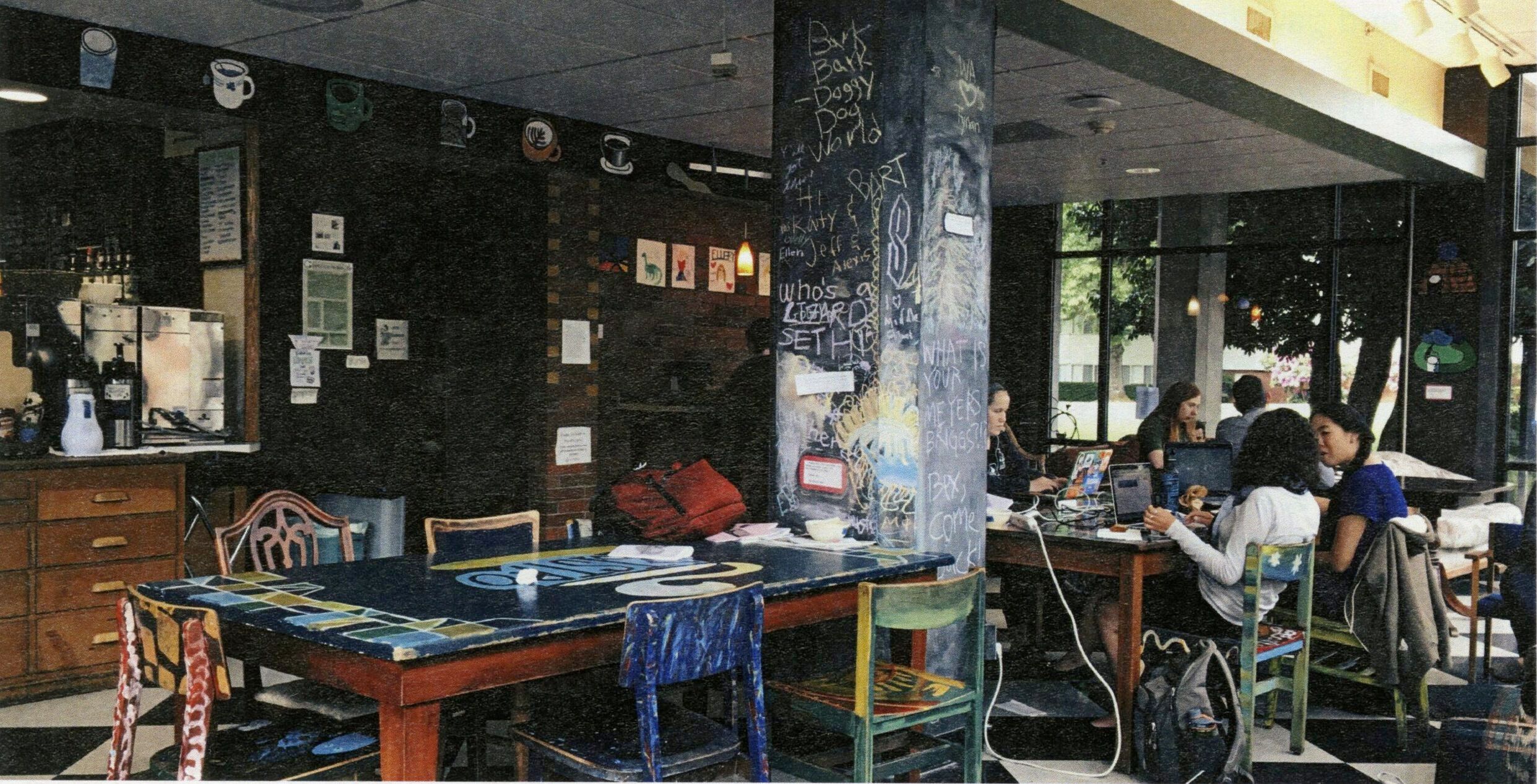 Students lounge and chat in the Bistro, which is furnished with colorfully painted chairs, a chalk-drawing covered pole and checkered floors.